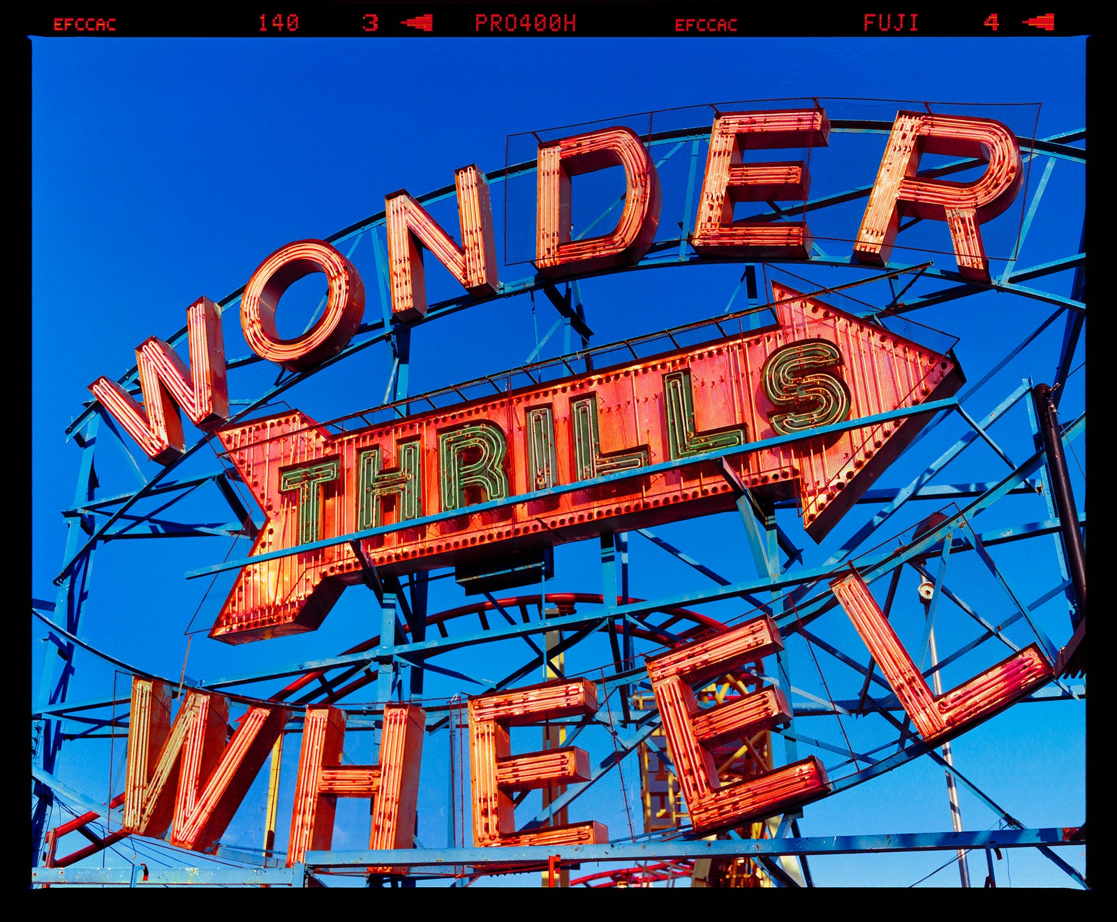 Neon sign for the Wonder Wheel amusement park against a blue sky typography photography by Richard Heeps