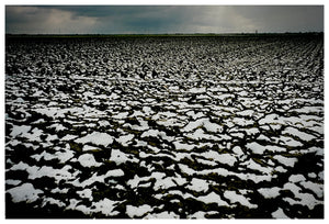 Photograph by Richard Heeps.  A peat field patched with snow. A vast sky sits at the very top of the photo.