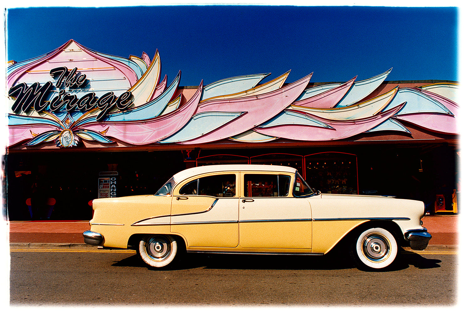 Photograph by Richard Heeps. A yellow classic American car sits on the road outside the Mirage amusement arcade in Hemsby, Norfolk.