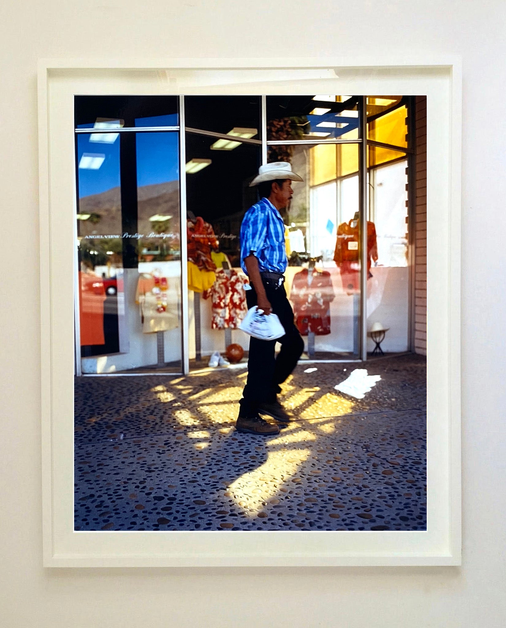 'Boutique' is street portrait, taken in Palm Springs, California. This piece is different from Richard Heeps' usual style, but everything fell into place: the light, the colours, and the man walking through the shot.