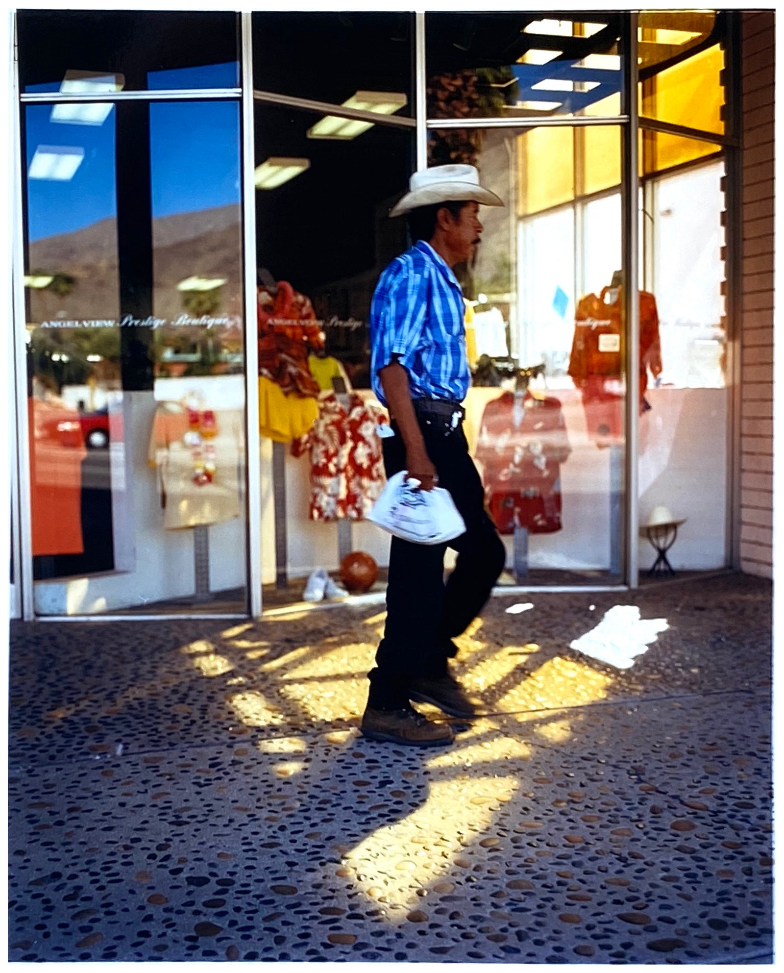 'Boutique' is street portrait, taken in Palm Springs, California. This piece is different from Richard Heeps' usual style, but everything fell into place: the light, the colours, and the man walking through the shot.