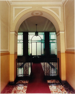 An Art Deco entrance hall in Milan, featuring stained glass panelling and marble flooring. 