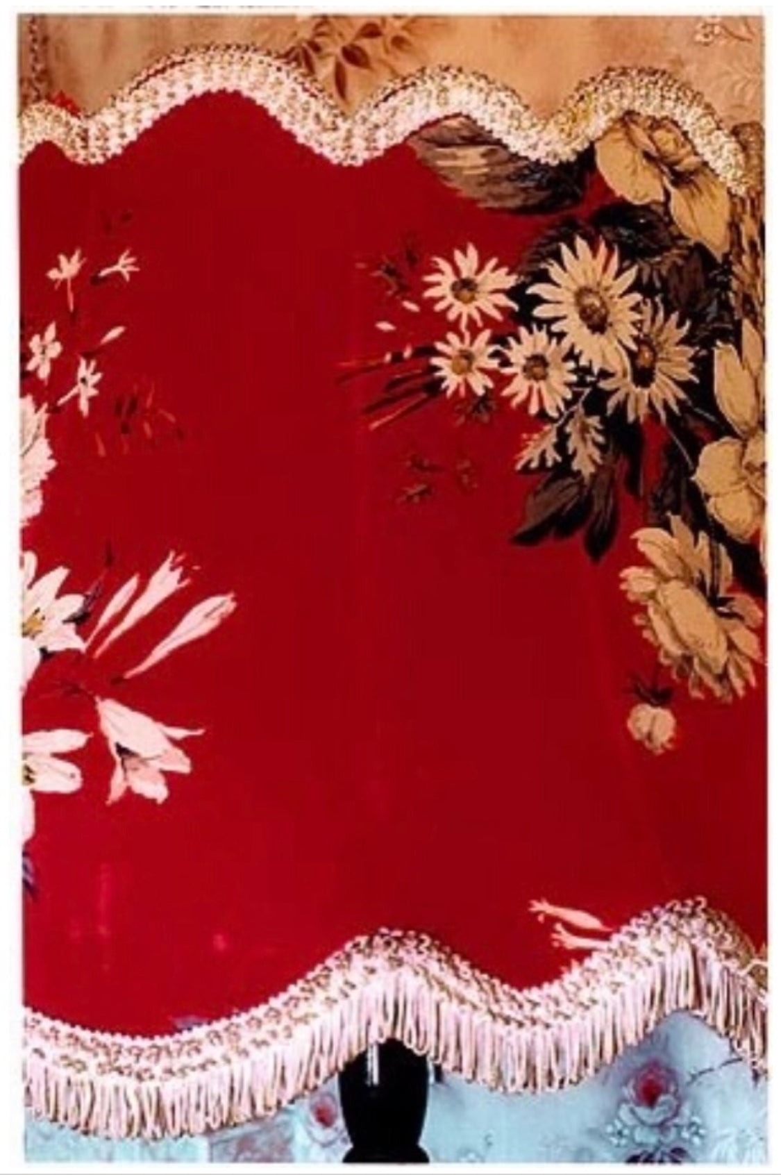 Floral detail on a red lampshade in a rural home.