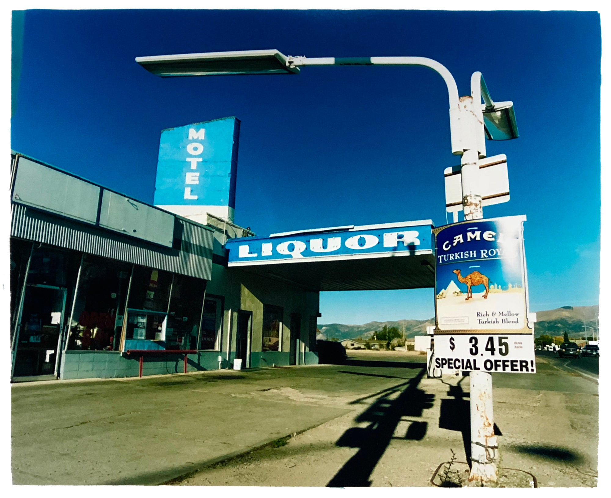 Monochrome blue photograph of a roadside America filling station artwork by Richard Heeps.