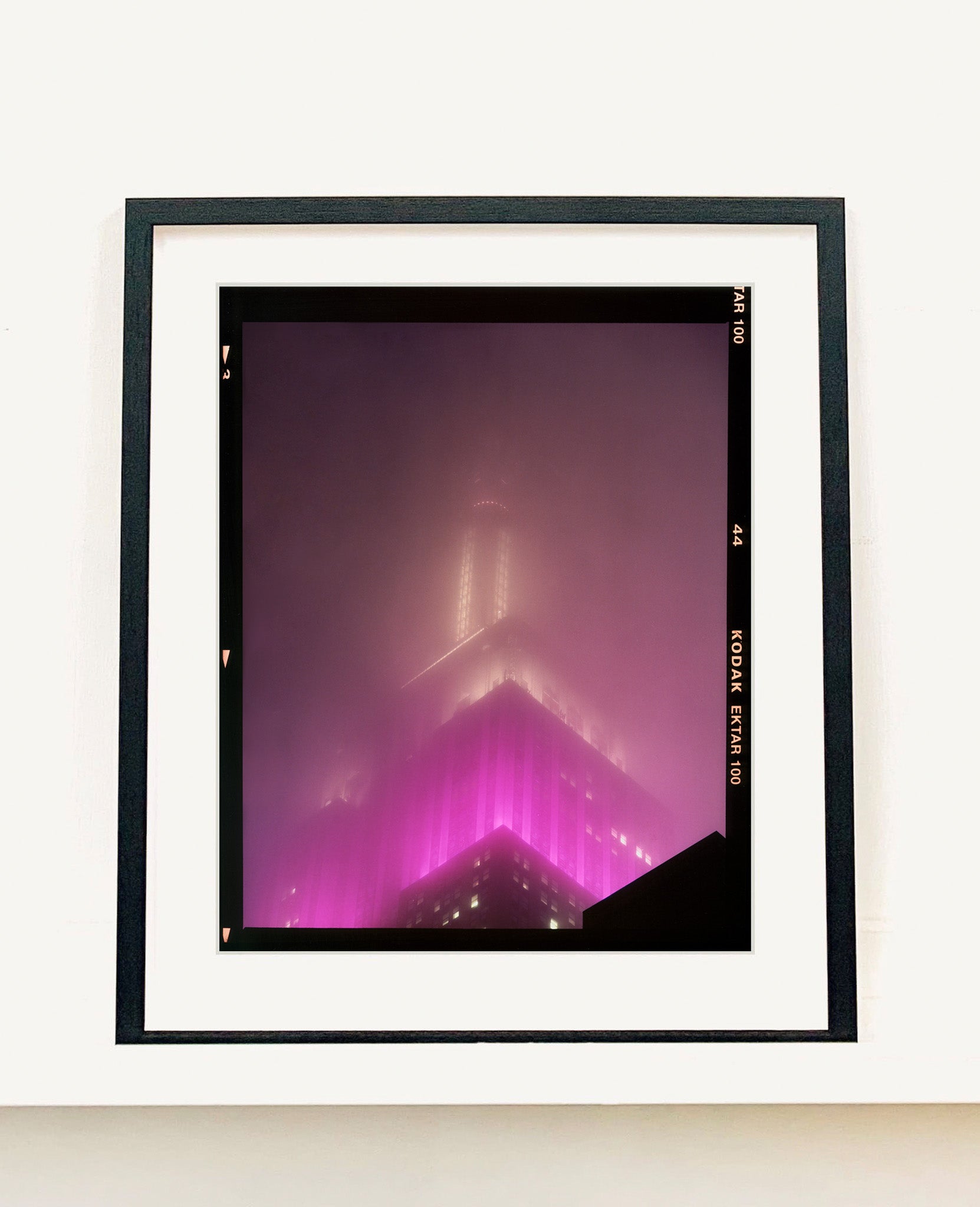 'NOMAD IX (Film Rebate)', New York. Richard Heeps has photographed the iconic Empire State building in the mist. The NOMAD sequence of photographs capture the art deco architecture illuminated by changing colours, and is part of Richard's street photography portfolio which depict the colour, fabric and structure of cities with distinct style. This 6x7 format edition is bordered by the Kodak film rebate. 
