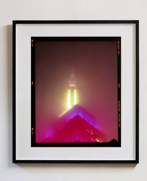 NOMAD, New York, photography by Richard Heeps capturing the iconic Empire State building in the mist. Part of a sequence of photographs capturing the art deco architecture illuminated in changing colours. This 6x7 format edition is bordered by the Kodak film rebate. This artwork is part of Richard's portfolio of street photography he is building up which depict the colour, fabric and structure of cities with distinct style