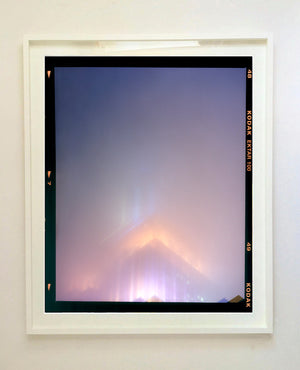 'NOMAD VI (Film Rebate)', New York. Richard Heeps has photographed the iconic Empire State building in the mist. The NOMAD sequence of photographs capture the art deco architecture illuminated by changing colours, and is part of Richard's street photography portfolio which depict the colour, fabric and structure of cities with distinct style. This 6x7 format edition is bordered by the Kodak film rebate. 