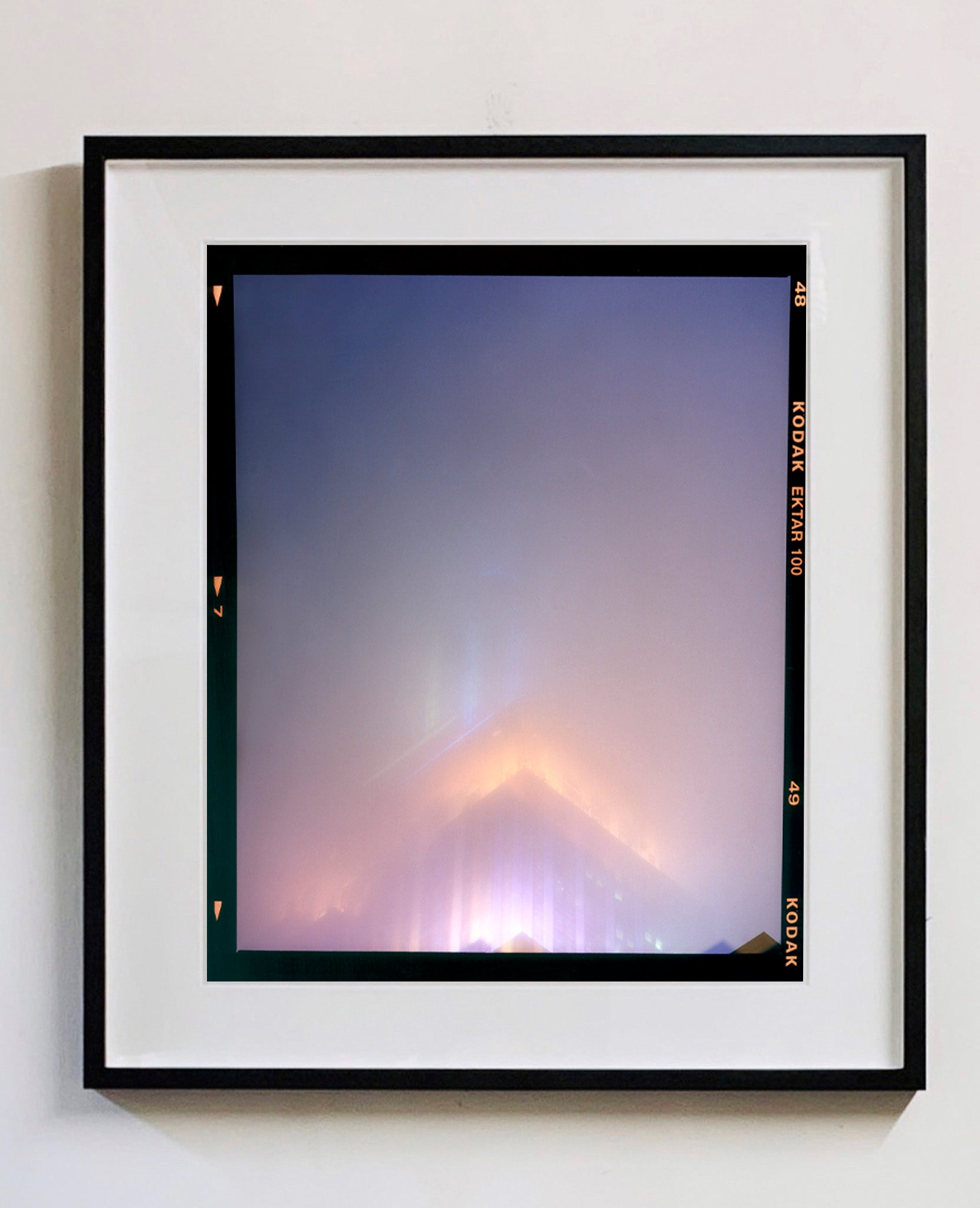 'NOMAD VI (Film Rebate)', New York. Richard Heeps has photographed the iconic Empire State building in the mist. The NOMAD sequence of photographs capture the art deco architecture illuminated by changing colours, and is part of Richard's street photography portfolio which depict the colour, fabric and structure of cities with distinct style. This 6x7 format edition is bordered by the Kodak film rebate. 