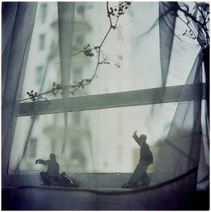Interior photograph by Richard Heeps taken in Hong Kong featuring figurines in Tai Chi form sitting on a window sill and veiled by a fine net curtain.