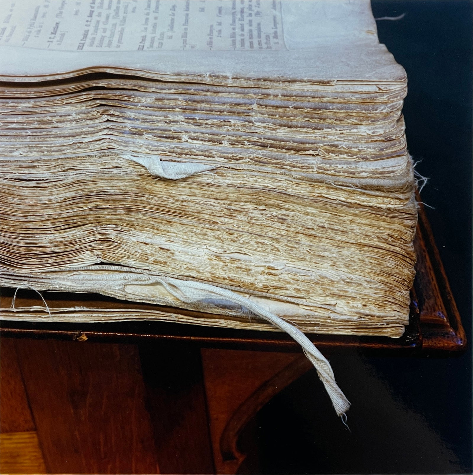Photograph by Richard Heeps.  A close up of a corner of an old, worn, battered, academic book.