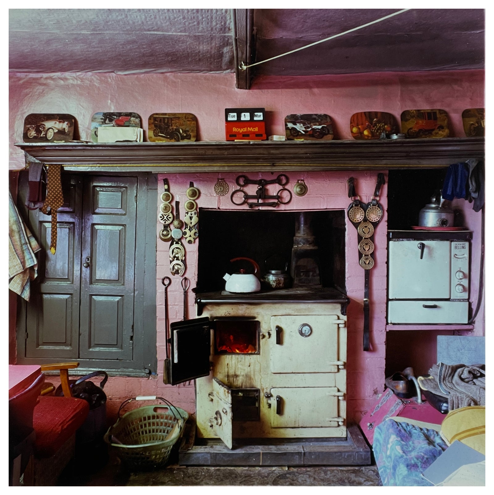 Photograph by Richard Heeps. A vintage farm hand cottage kitchen. Featuring an aga, pink walls, bedecked with horse tack as well as other fascinating items.