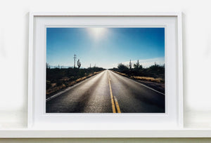 'Road to Gunsight' photographed on Highway 86, Arizona in 2001 is part of Richard Heeps' 'Dream in Colour' series. This classic American open road imagery appears throughout his work. 