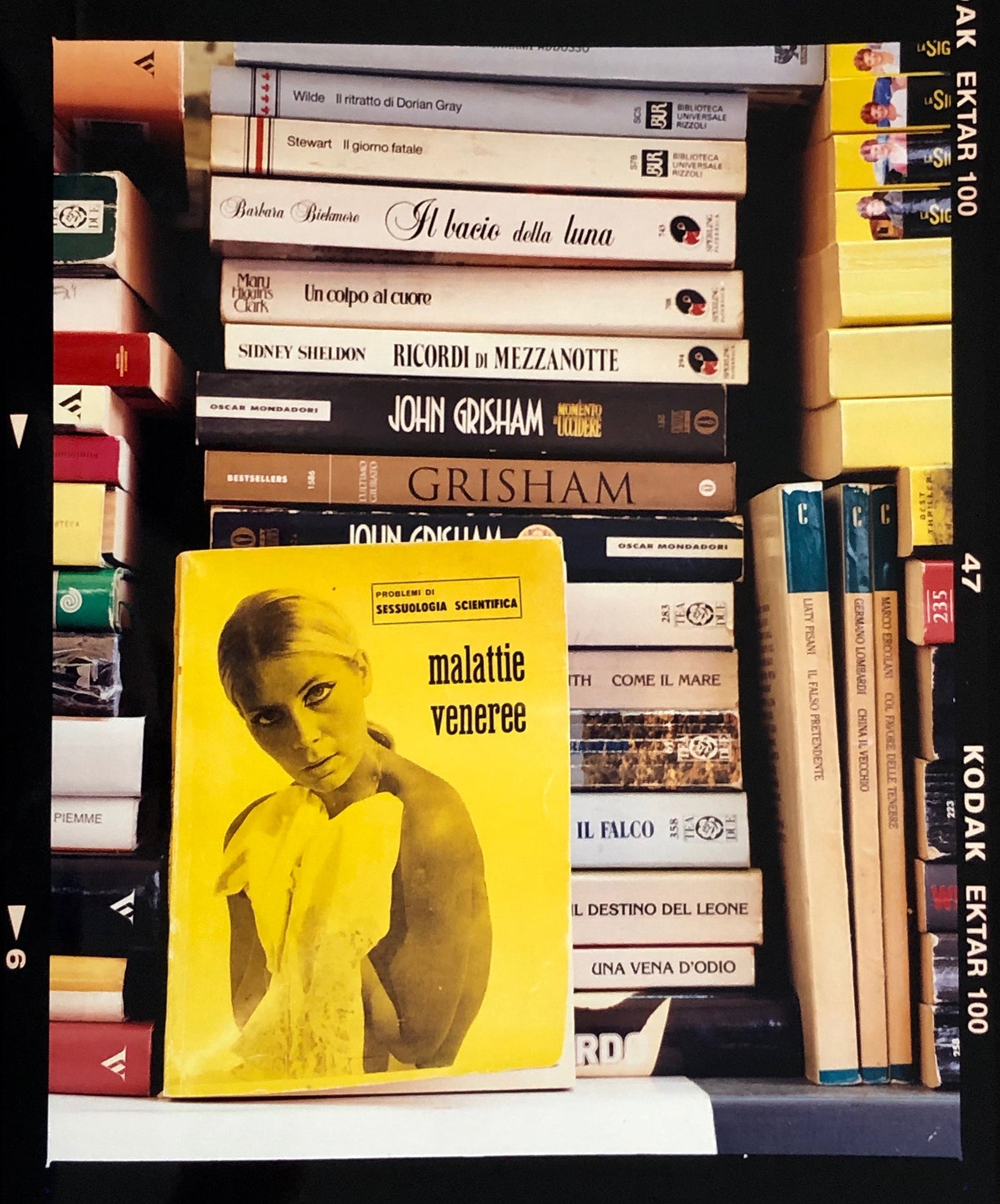 ‘Scientific Sexology’ sits amongst a stack of books street photography by Richard Heeps in Milan, Italy.