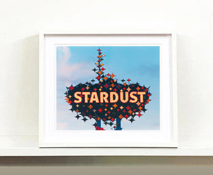 'Stardust', shows a sparkling roadside sign against a bright blue and slightly clouded sky. This artwork offers a classic Americana feel and incorporates elements of Googie style design. Richard Heeps beautifully captures parts of Las Vegas which are no longer there. This photograph was taken in 2001 but only made in Richard's darkroom for the first time in 2017.