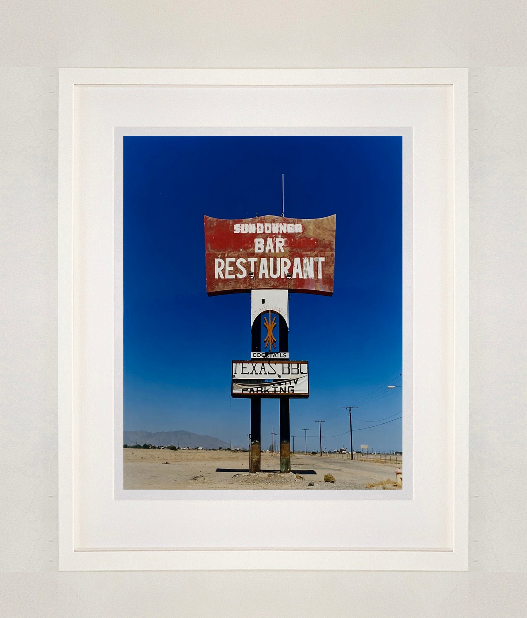 This giant isolated roadside sign set against a vast blue sky is a remnant of The Sundowner Bar and Restaurant of the Motel which is sadly no more. This photograph, part of Richard Heeps' 'Salton Sea' series captures the landscape of the western side of the lake.