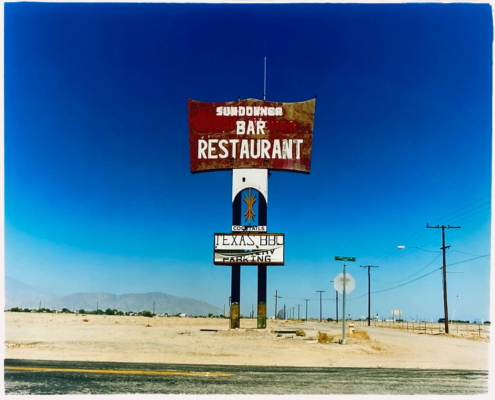 This isolated giant great roadside sign set against a vast blue sky is a remnant of The Sundowner Bar and Restaurant of the Motel which is unfortunately no more. This photograph, part of Richard Heeps Salton Sea Series captures the landscape of the western side of the lake.