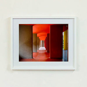 Red and yellow brutalist concrete architecture photograph by Richard Heeps framed in white.