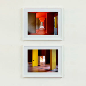 Red and yellow brutalist concrete architecture photograph by Richard Heeps framed in white paired with Monte Amiata.