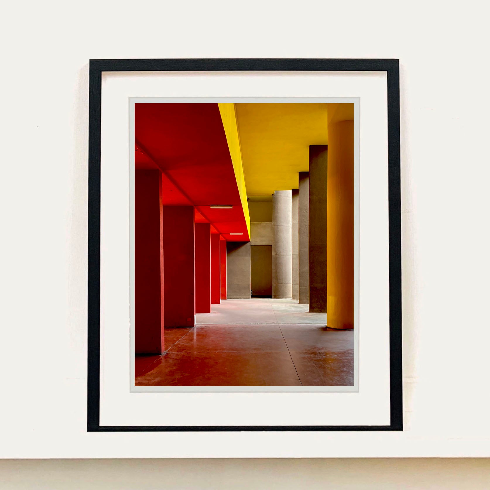 Monte Amiata housing, Gallaratese Quarter, Milan. Red and yellow brutalist architecture photograph by Richard Heeps framed in black.