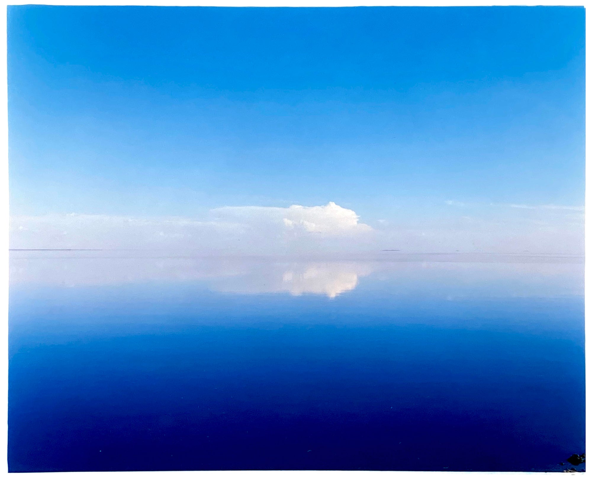 'View from Bombay Beach' looks over Salton Sea in California. Cooling shades of blue, reflection and symmetry are key to this serene waterscape. The suspended cloud which looks surreal creates a feeling of weightlessness. 
