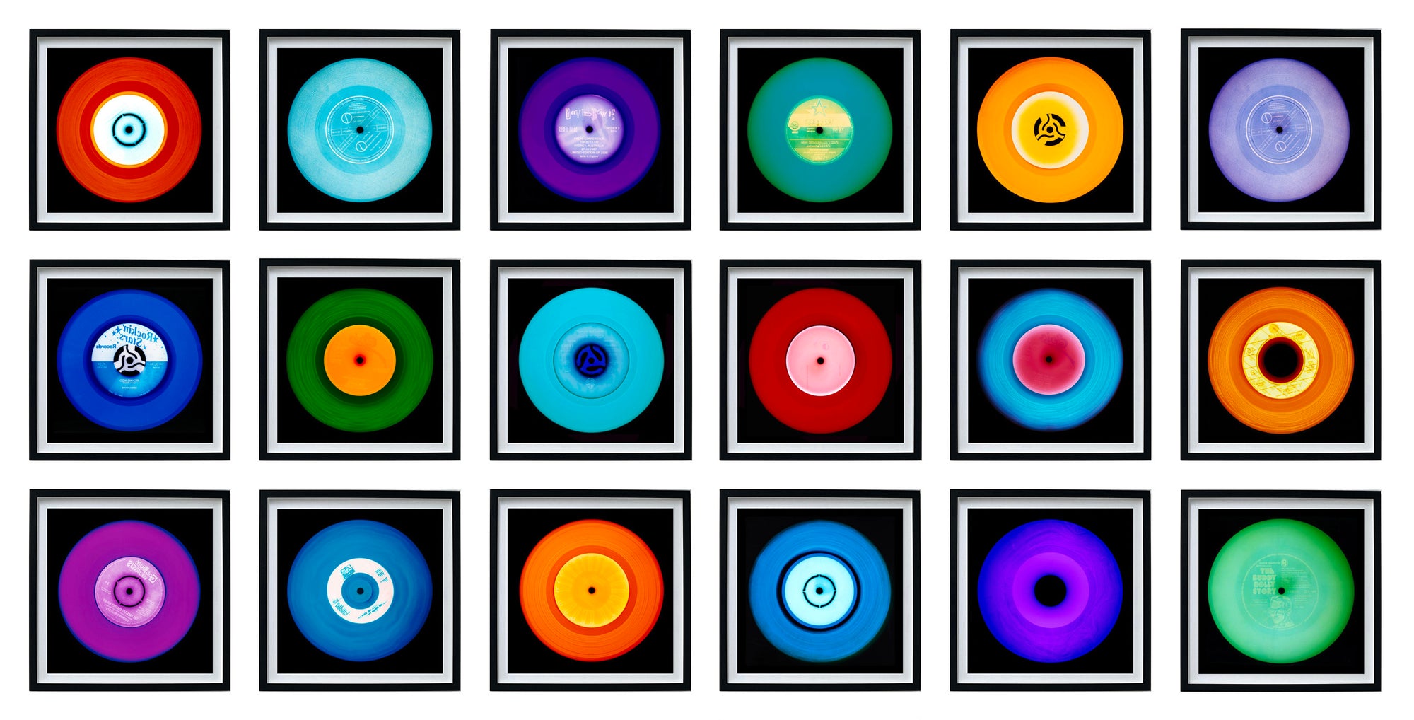 Photograph by Heidler and Heeps.  Eighteen coloured vinyls in black frames, in a 3 x 6 figuration.