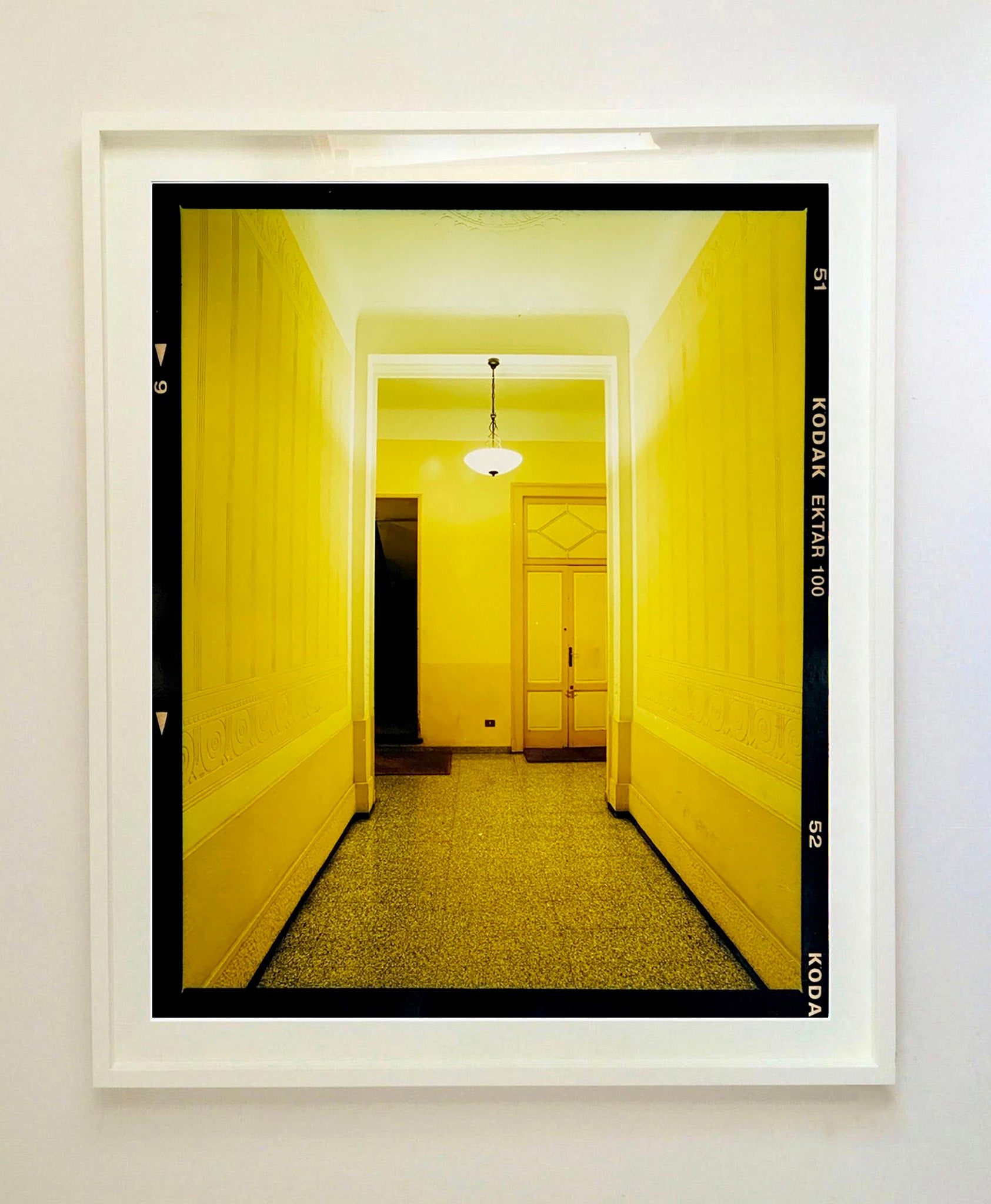 A yellow glow fills the corridor of an apartment foyer in Milan. 